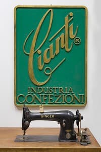 Cianti — Industria Confezioni enamel sign with Singer sewing machine